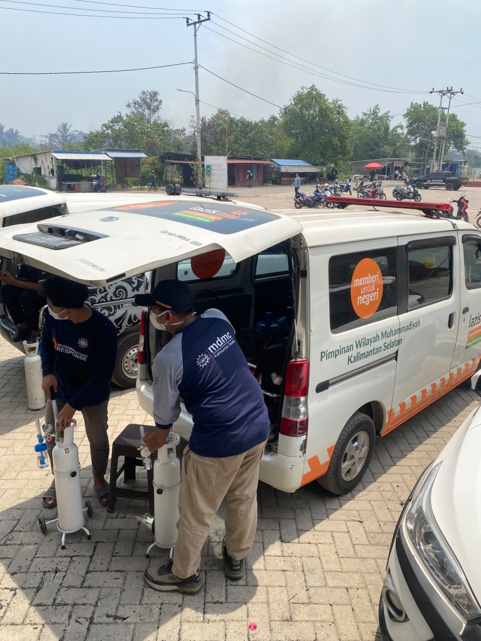Ambulans dan relawan Lazismu Kalsel bersiaga memberikan oksigen dan masker di tengah kobaran api karhutla yang masih menyala di sekitar Kampus Uniska Handil Bakti.